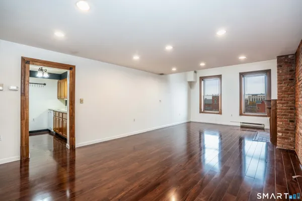 a living room with a wooden floor and a fireplace