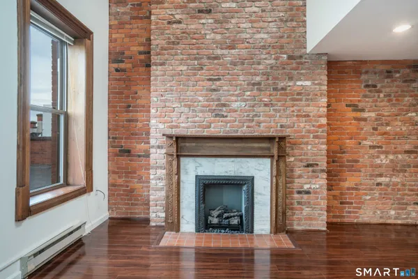 a view of a livingroom with wooden floor and a fireplace