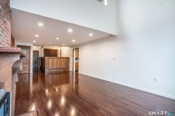 a view of a hallway with wooden floor and entryway