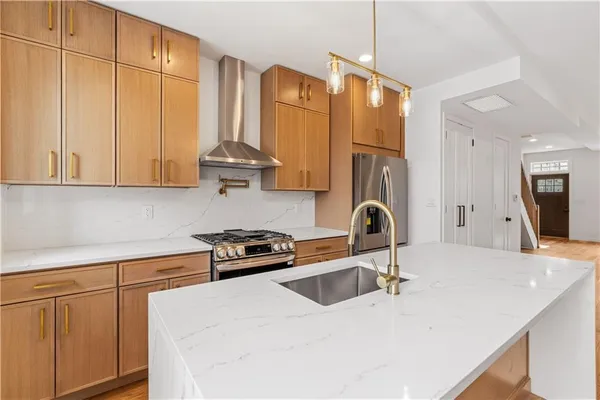 a kitchen with stainless steel appliances granite countertop a sink a stove and a refrigerator