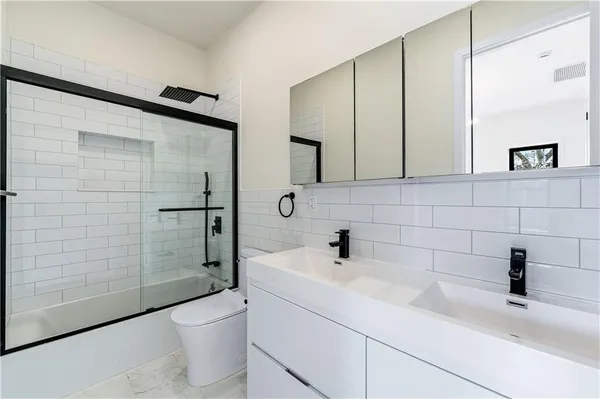 a bathroom with a sink a toilet and shower