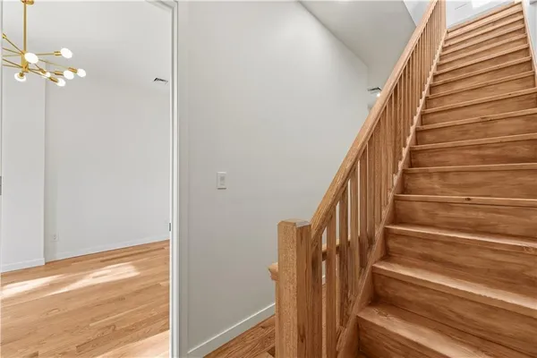 a view of staircase with wooden floor and white walls