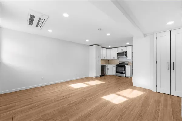 a view of empty room with wooden floor