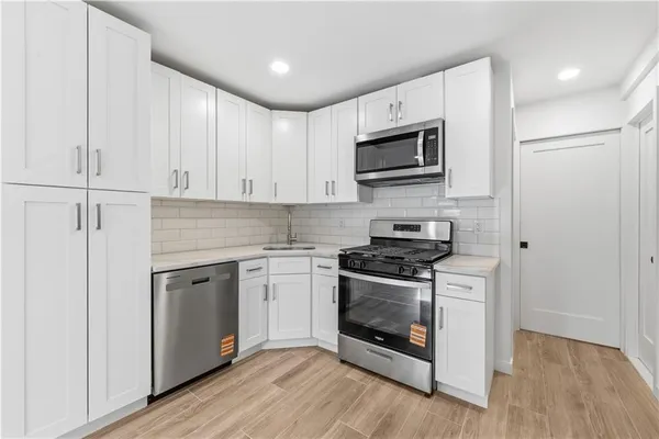 a kitchen with stainless steel appliances granite countertop a stove top oven a sink and a microwave