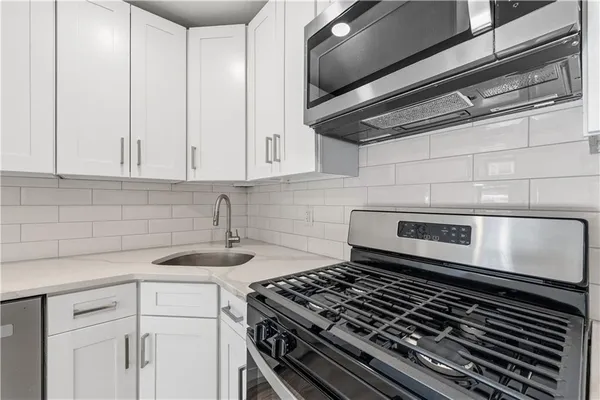 a stove top oven sitting inside of a kitchen
