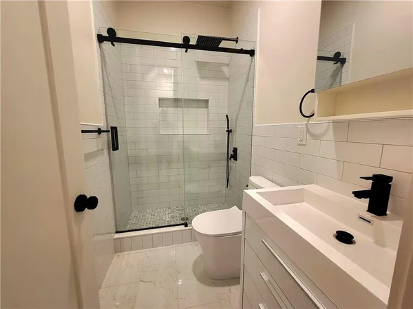a bathroom with a sink a toilet and shower
