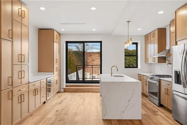 a kitchen with stainless steel appliances granite countertop a sink a stove and a refrigerator