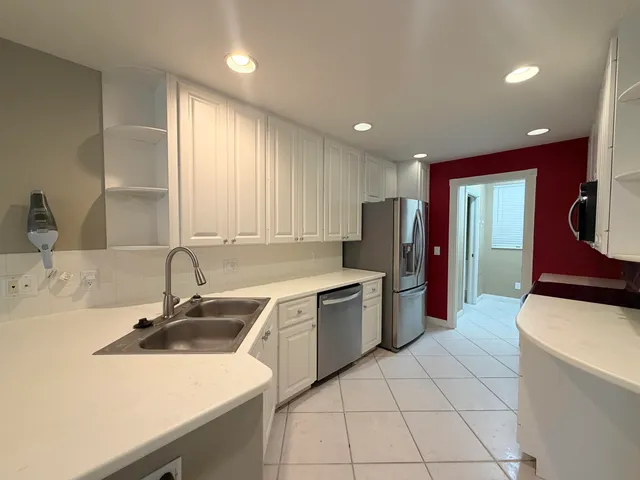 a kitchen that has a sink a stove top oven a refrigerator and a sink