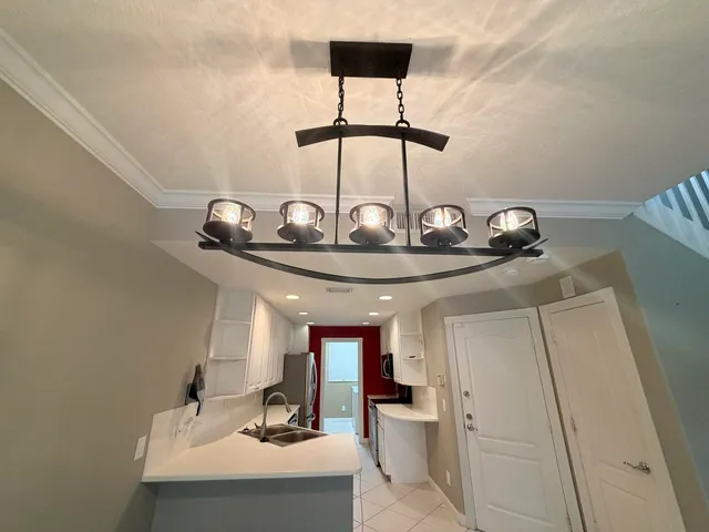 a view of a center kitchen island with a sink and cabinets