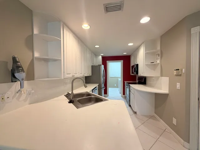 a room with a bed a table a flat screen tv and window