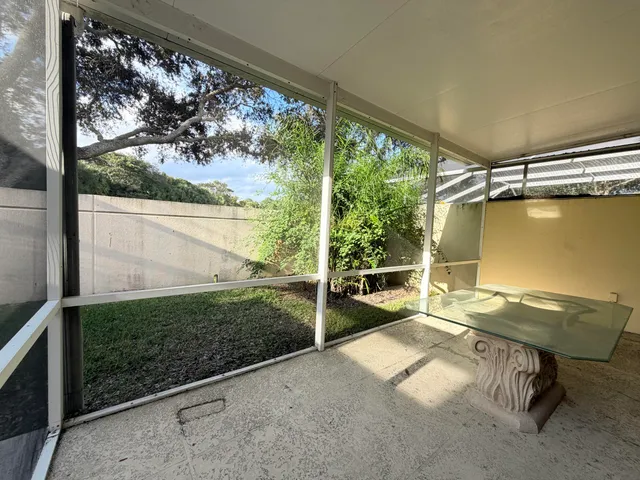a view of a porch with furniture and floor to ceiling window