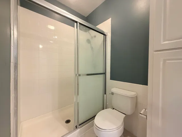 a bathroom with a shower a toilet and a sink