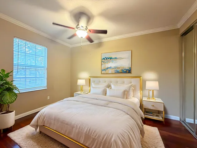 a bedroom with a large bed and a potted plant