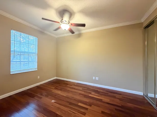 a view of a room with wooden floor and fan