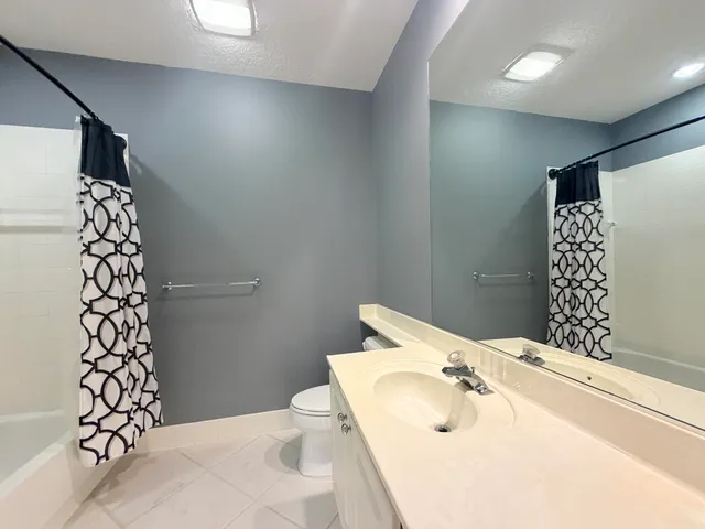 a bathroom with a sink and mirror with toilet