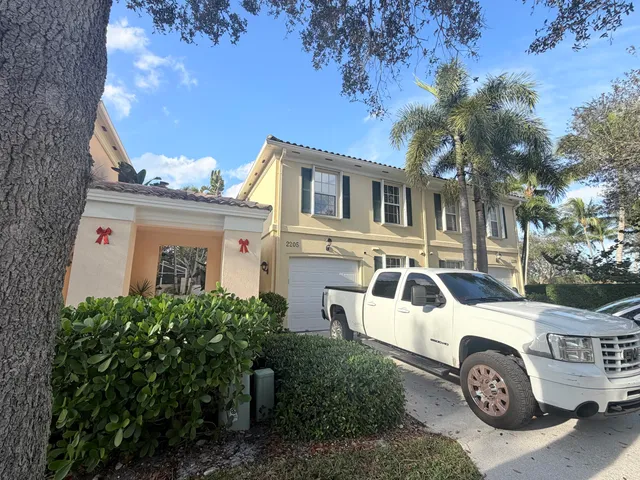 a white house with a outdoor space and garden