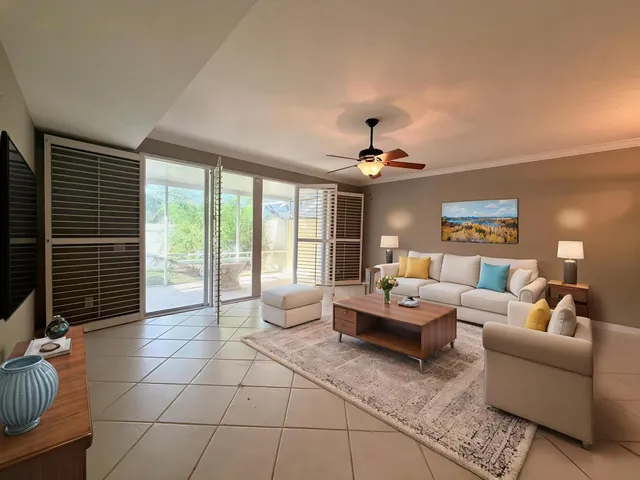 a living room with furniture and a floor to ceiling window