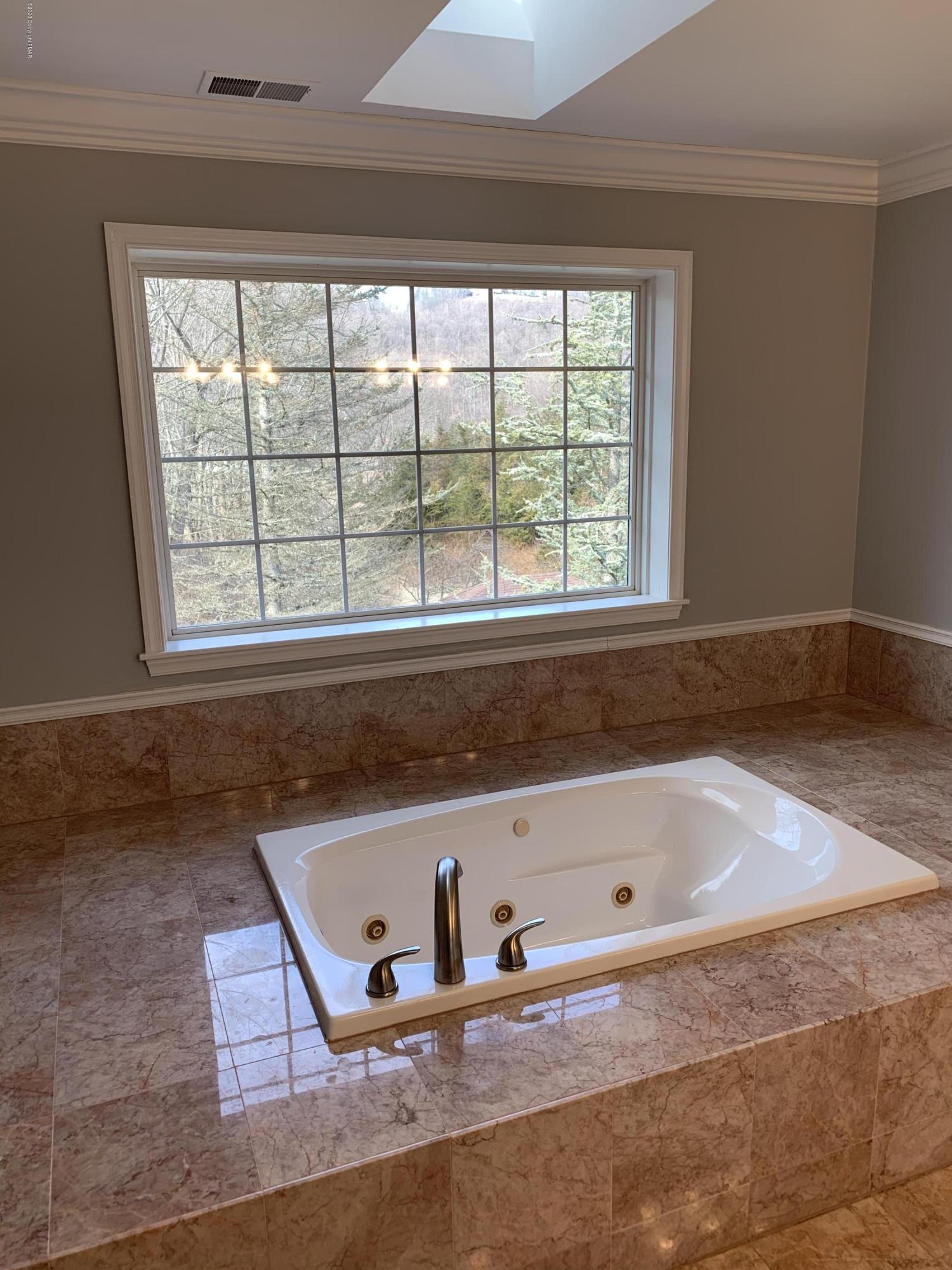 1697 Middle Road Stroudsburg, PA 18360 - Photo 82 of 116 a bath tub sitting in a bathroom next to a window