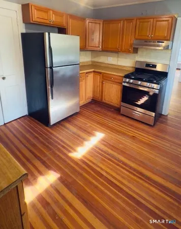a kitchen with granite countertop wooden cabinets stainless steel appliances and a counter space
