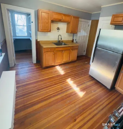 a kitchen with stainless steel appliances granite countertop a sink and wooden floors