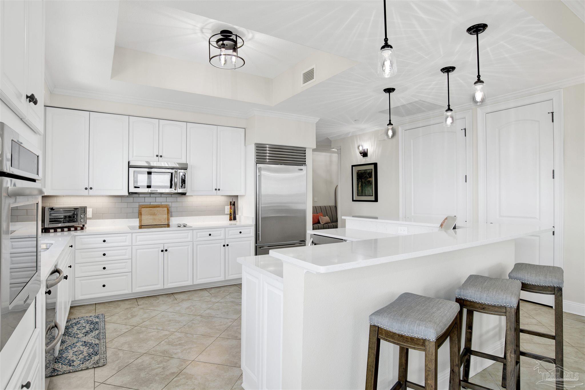 14500 River Road, Unit 507 Pensacola, FL 32507 - Photo 8 of 56 a kitchen with white cabinets and stainless steel appliances