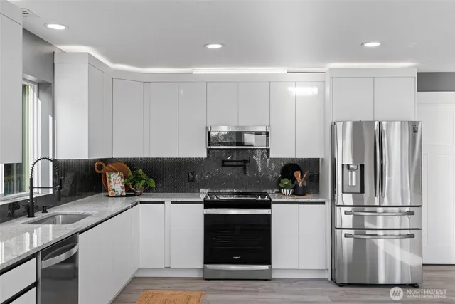 a kitchen with stainless steel appliances a refrigerator sink and microwave