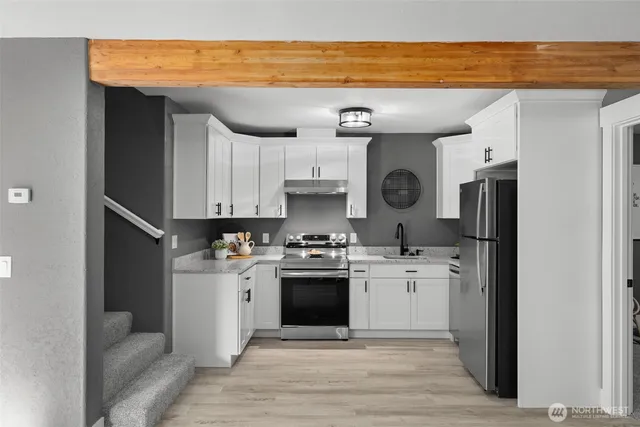 a kitchen with stainless steel appliances granite countertop a refrigerator and a stove top oven