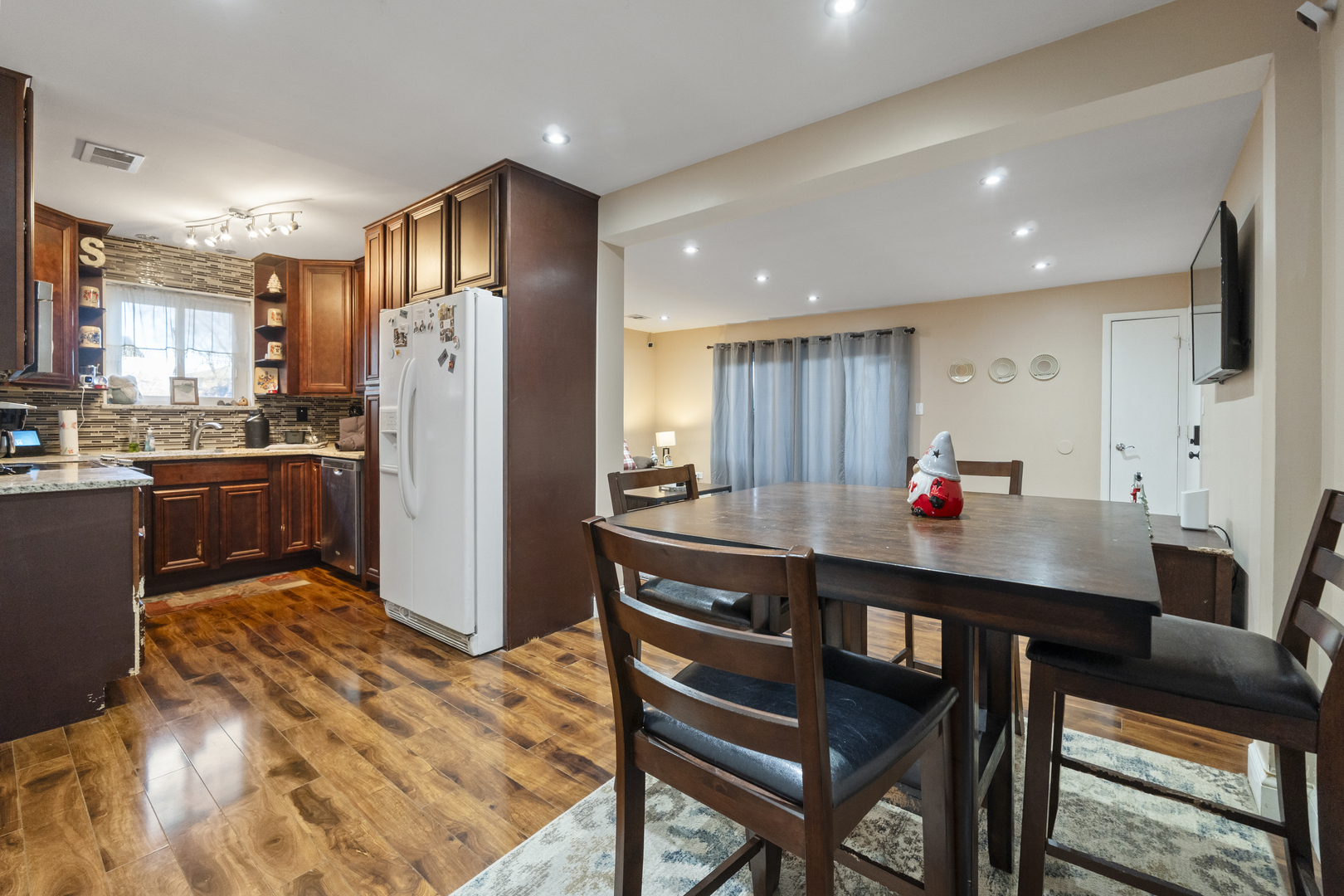 9645 South Harlem Avenue, Unit 1H Chicago Ridge, IL 60415 - Photo 11 of 14 a kitchen with stainless steel appliances granite countertop a dining table chairs refrigerator and sink