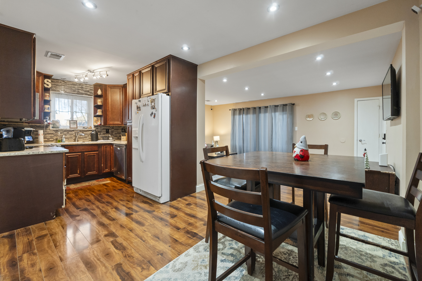 9645 South Harlem Avenue, Unit 1H Chicago Ridge, IL 60415 - Photo 3 of 14 a kitchen with stainless steel appliances kitchen island granite countertop a refrigerator a stove a sink a dining table and chairs with wooden floor