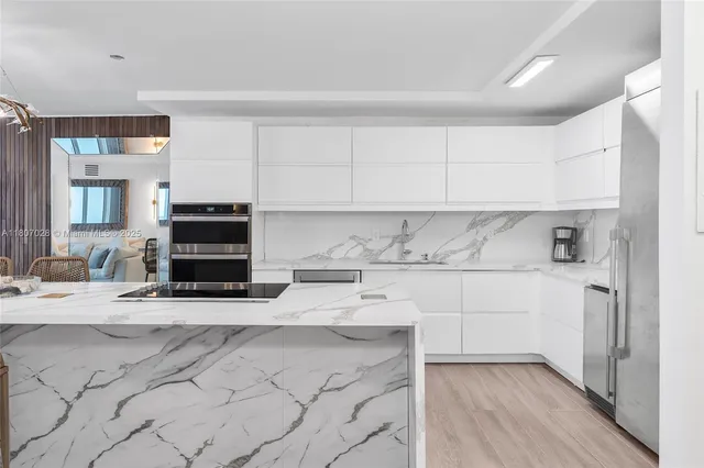a kitchen with stainless steel appliances a stove a sink and a refrigerator