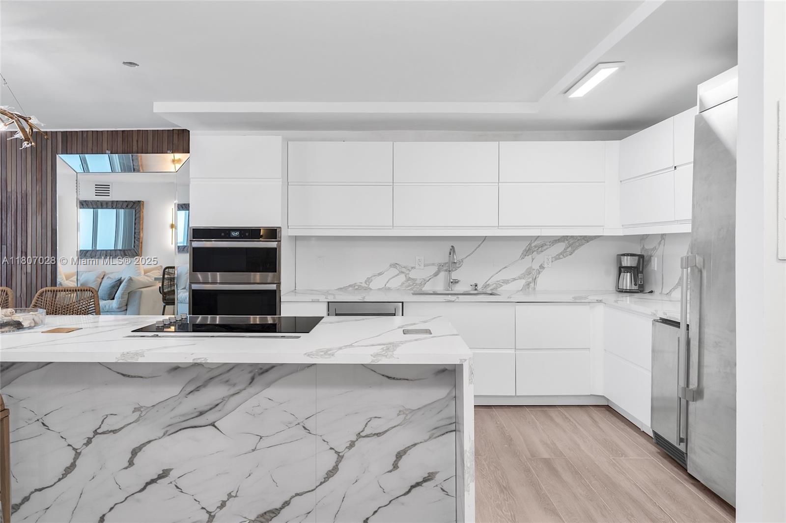 2301 Collins Avenue, Unit 1019 Miami Beach, FL 33139 - Photo 12 of 35 a kitchen with stainless steel appliances a stove a sink and a refrigerator
