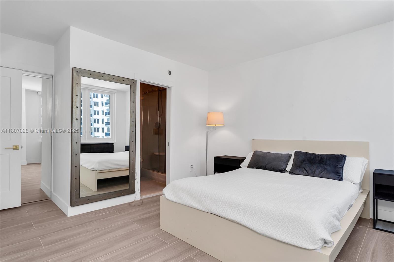 2301 Collins Avenue, Unit 1019 Miami Beach, FL 33139 - Photo 25 of 35 a bedroom with a large bed and wooden floor