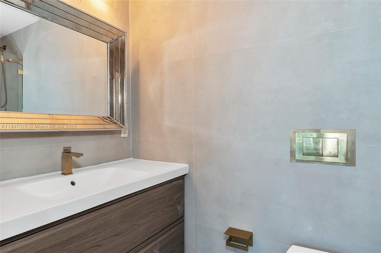 2301 Collins Avenue, Unit 1019 Miami Beach, FL 33139 - Photo 27 of 35 a bathroom with a sink and a mirror