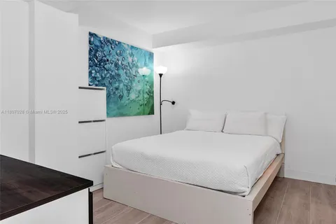 a bed sitting in a bedroom next to a window