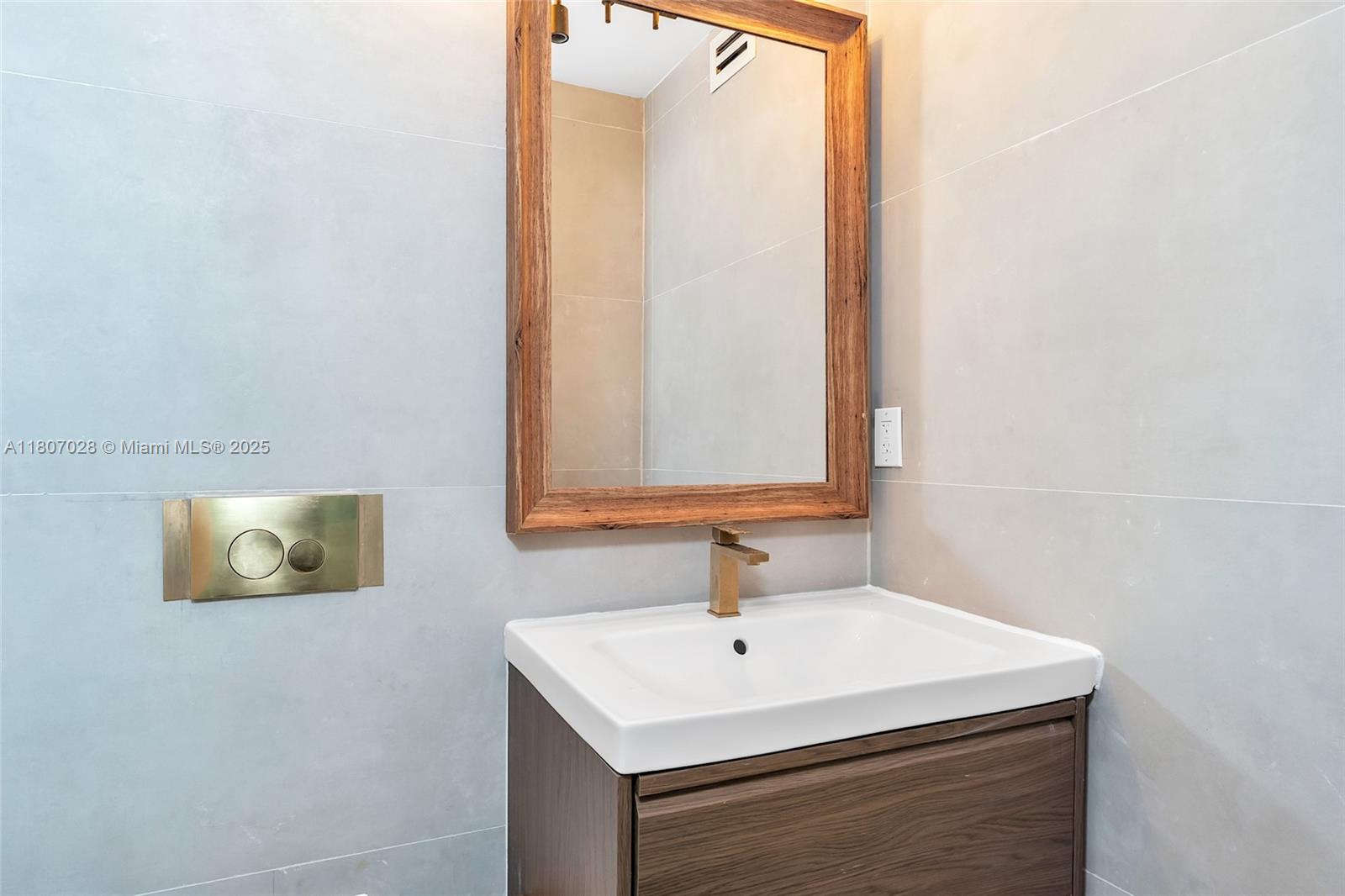 2301 Collins Avenue, Unit 1019 Miami Beach, FL 33139 - Photo 33 of 35 a bathroom with a sink and a mirror