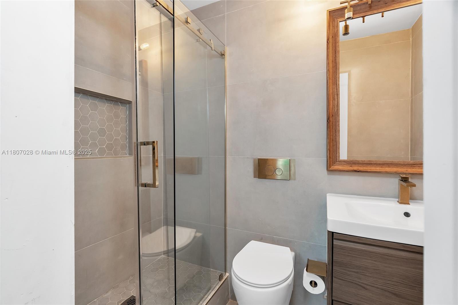 2301 Collins Avenue, Unit 1019 Miami Beach, FL 33139 - Photo 34 of 35 a bathroom with a toilet a sink and shower