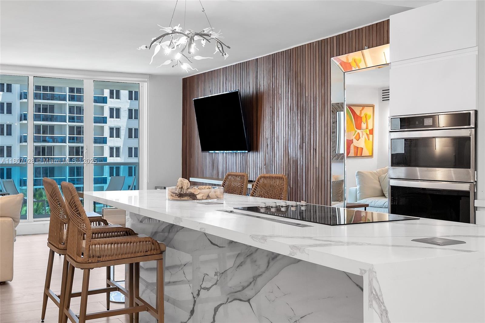 2301 Collins Avenue, Unit 1019 Miami Beach, FL 33139 - Photo 4 of 35 a living room with furniture a flat screen tv and a chandelier