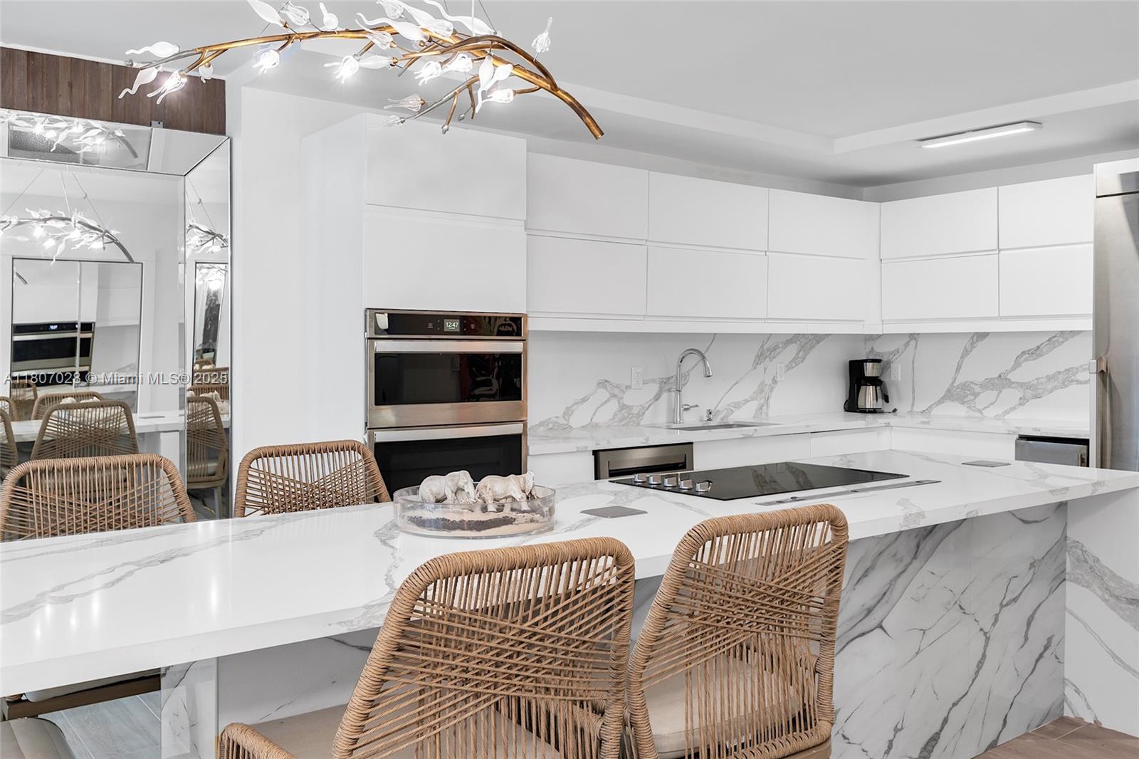 2301 Collins Avenue, Unit 1019 Miami Beach, FL 33139 - Photo 5 of 35 a kitchen with stainless steel appliances kitchen island granite countertop a sink and a white cabinets