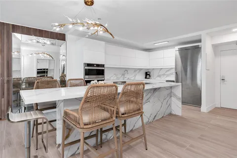 a living room with stainless steel appliances kitchen island granite countertop furniture and fireplace