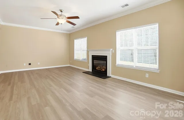 a view of empty room with fireplace and fan
