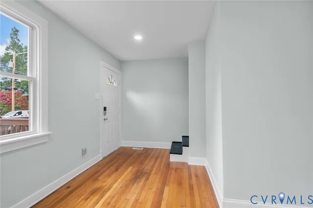 a view of a room with wooden floor and small window