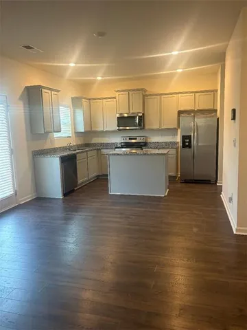 a kitchen with cabinets and wooden floor