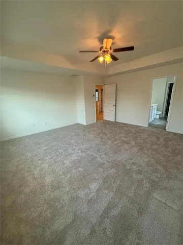 an empty room with a ceiling fan and window