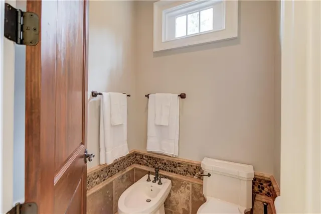 a bathroom with a sink a toilet and a mirror