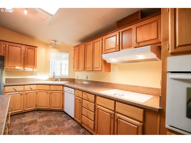 a kitchen with stainless steel appliances granite countertop a sink and dishwasher a stove with wooden floor