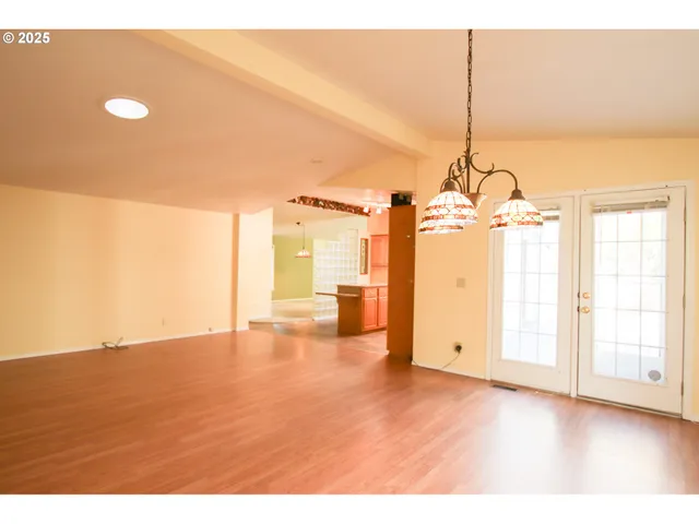 a view of empty room with wooden floor and windows