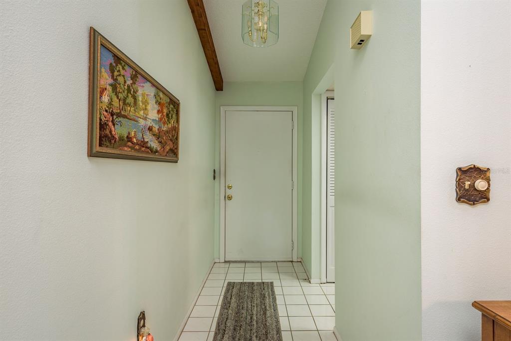 9910 Eagles Point Circle, Unit 3 Port Richey, FL 34668 - Photo 5 of 25 a view of a hallway with paintings on the wall