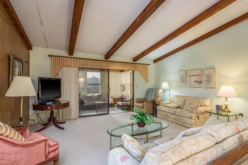 9910 Eagles Point Circle, Unit 3 Port Richey, FL 34668 - Photo 8 of 25 a living room with furniture and a flat screen tv