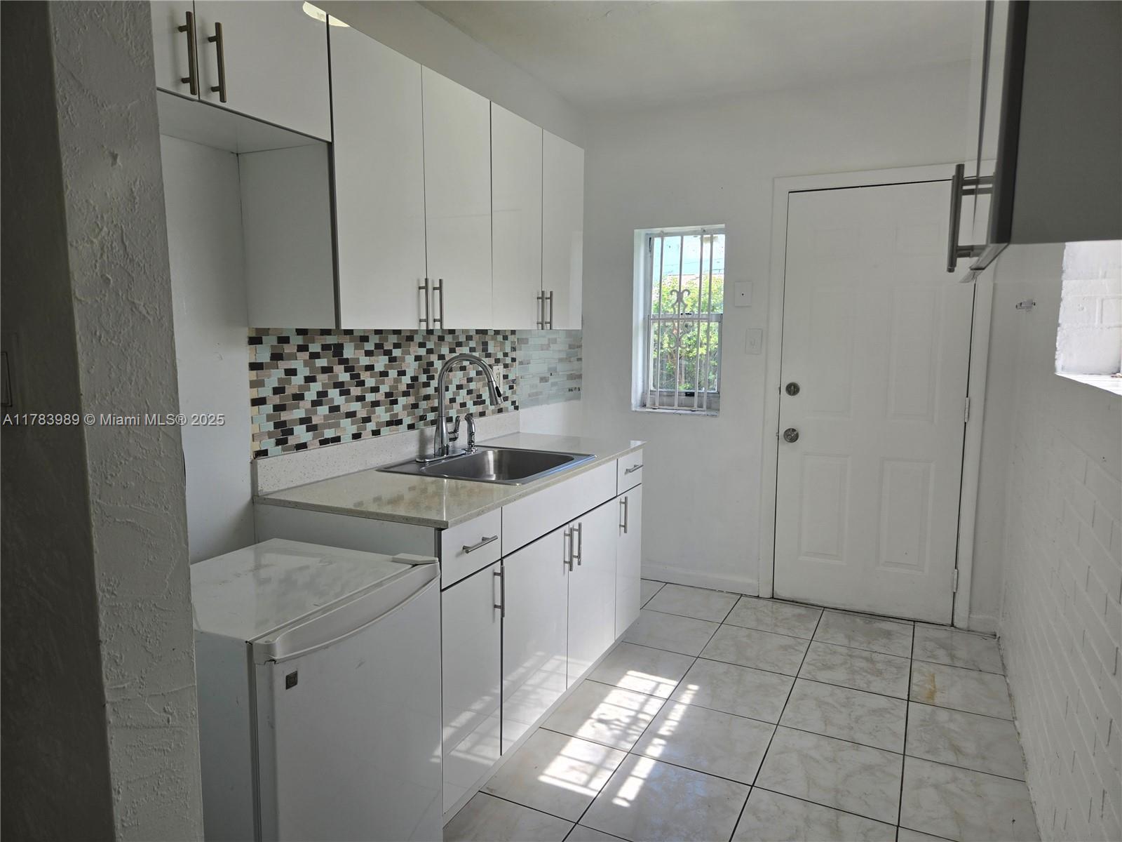 3310 Northwest 214th Street Miami Gardens, FL 33056 - Photo 12 of 17 a kitchen with stainless steel appliances granite countertop a sink and a refrigerator