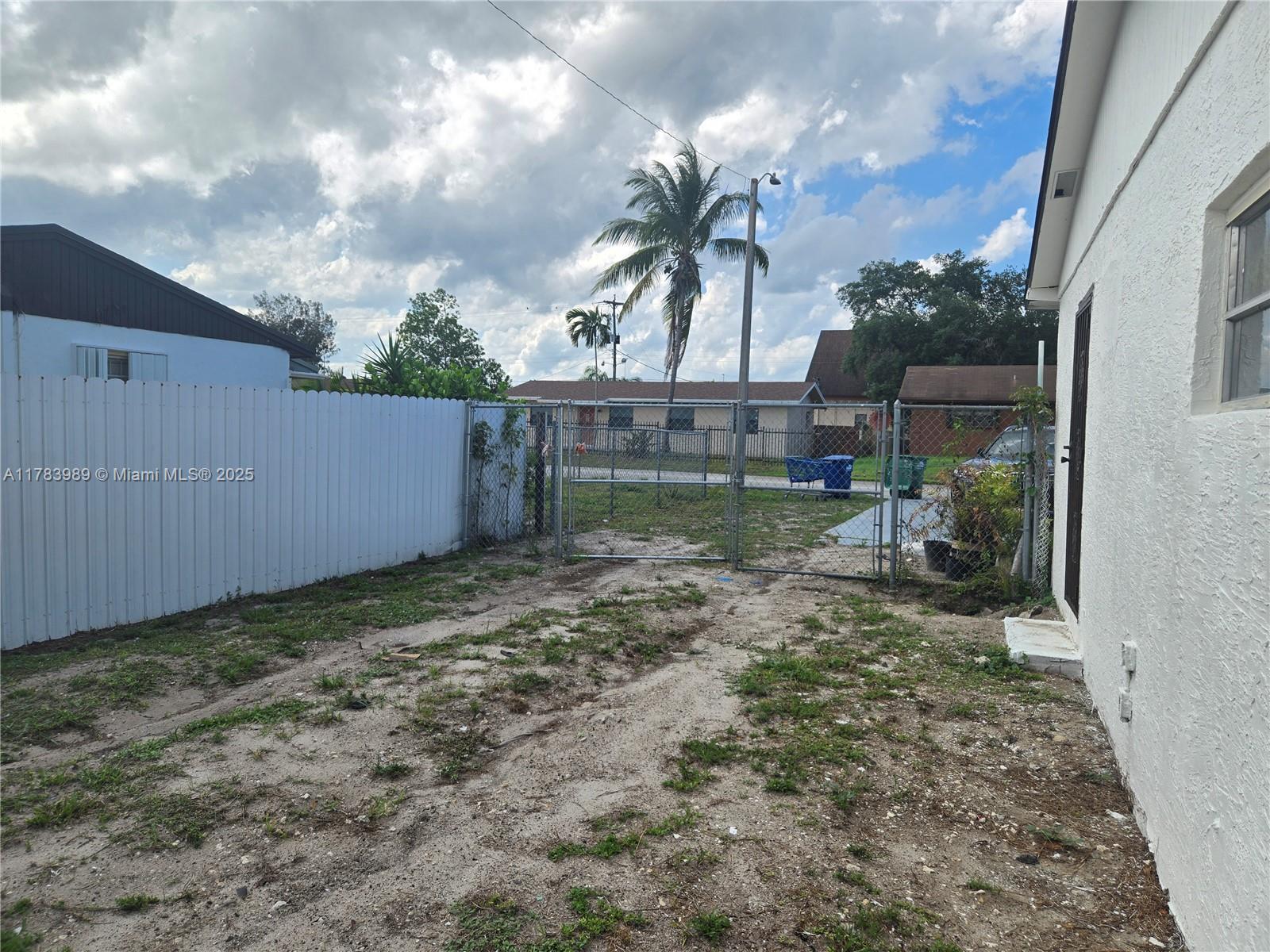 3310 Northwest 214th Street Miami Gardens, FL 33056 - Photo 16 of 17 a backyard of a house with lots of green space